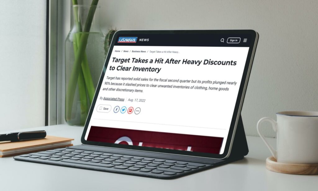Laptop with news headline: 'Target Takes a Hit After Heavy Discounts to Clear Inventory'
